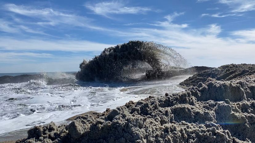 A mixture of sand and water comes out of a pipe at Wrightsville Beach. (Spectrum News 1/Natalie Mooney)